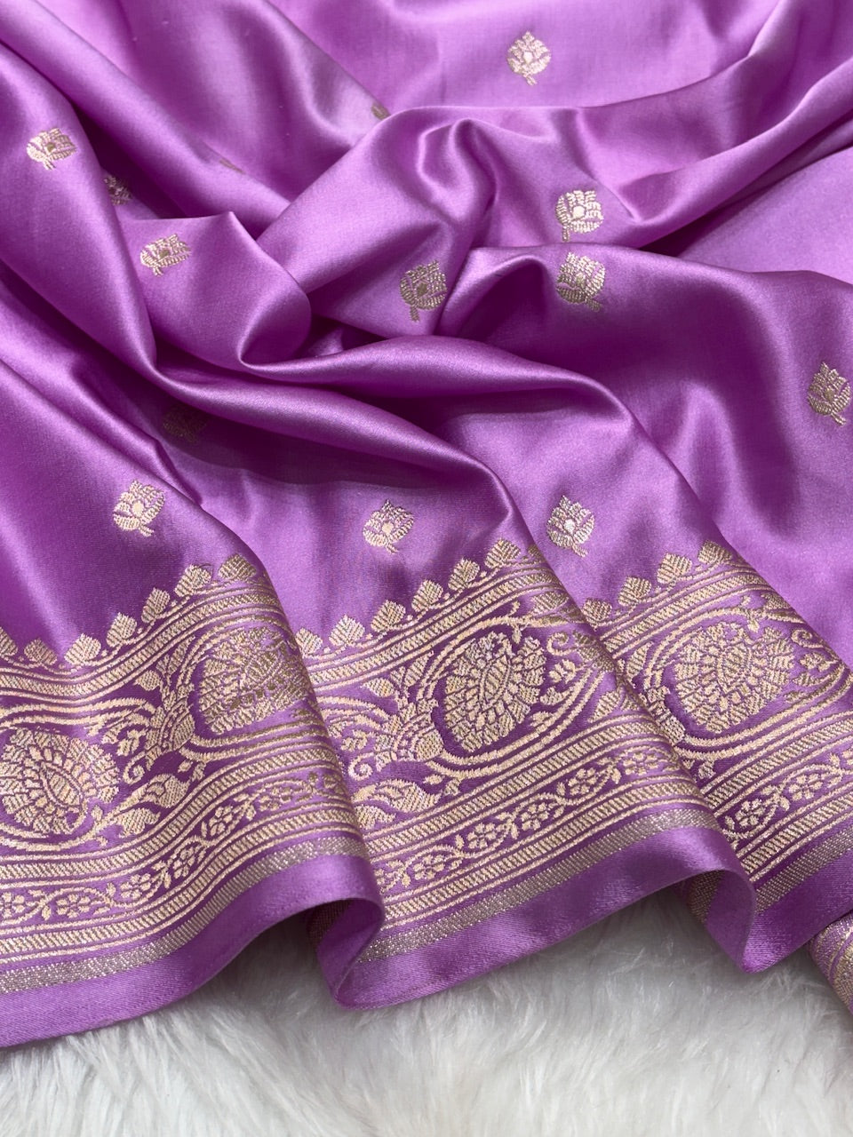 Purple saree with gold embroidery on a white background